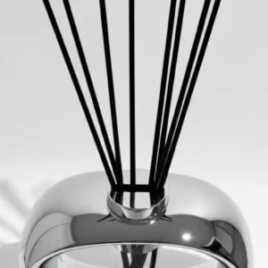 Chrome reed diffuser with black reeds in a reflective round bottle
